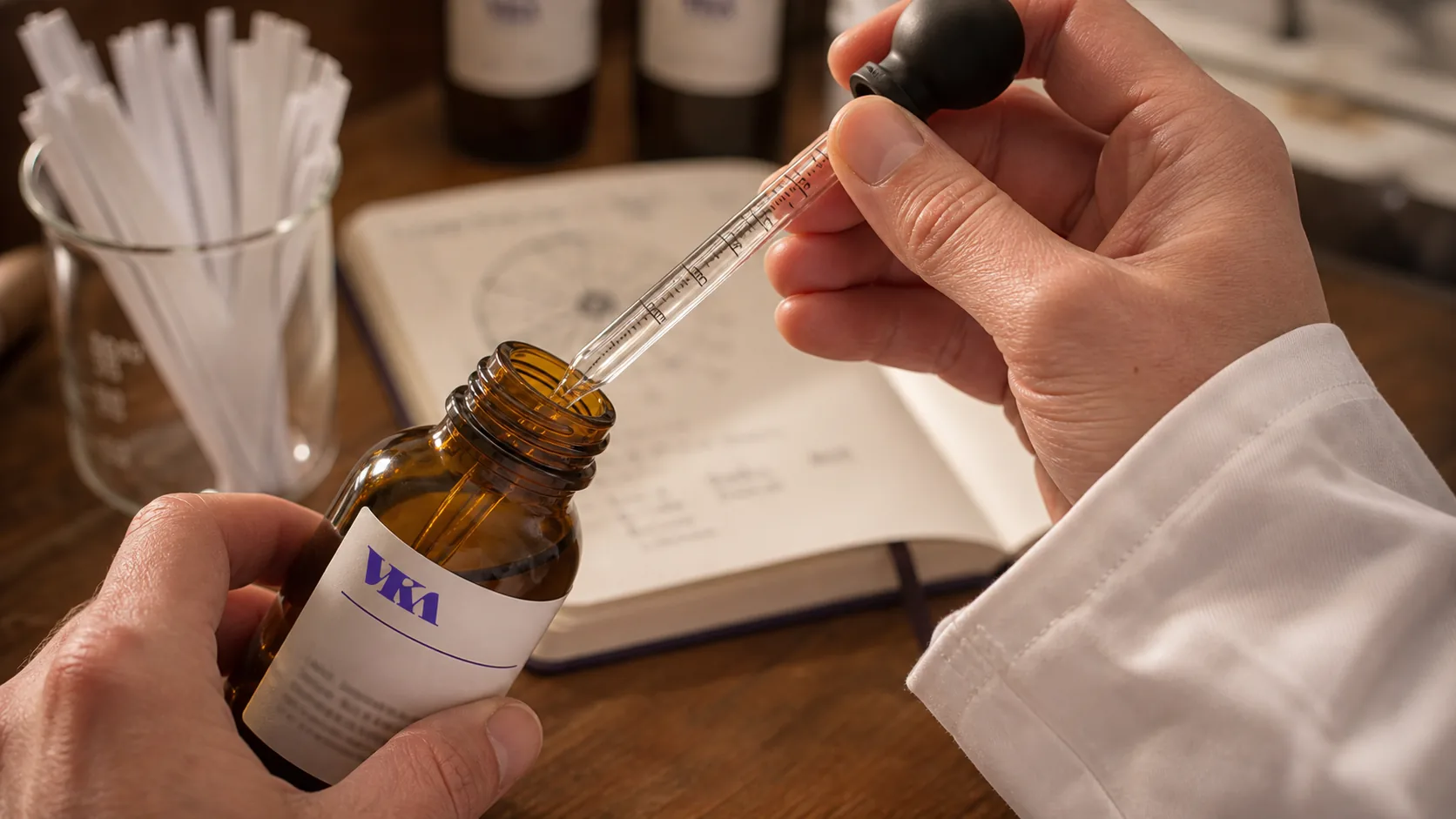 A VKA Australia flavourist pipetting essence from an amber bottle at the Southport compounding bench.